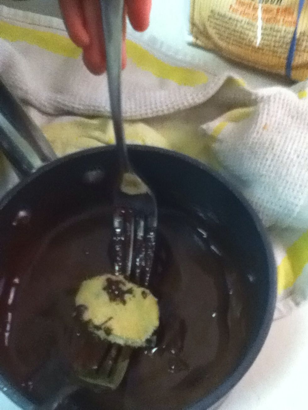 Using two forks, dip the eggs into the chocolate. Make sure the chocolate has cooled and the dough is cold. If it is melty, pop it back into the freezer for a few minutes.