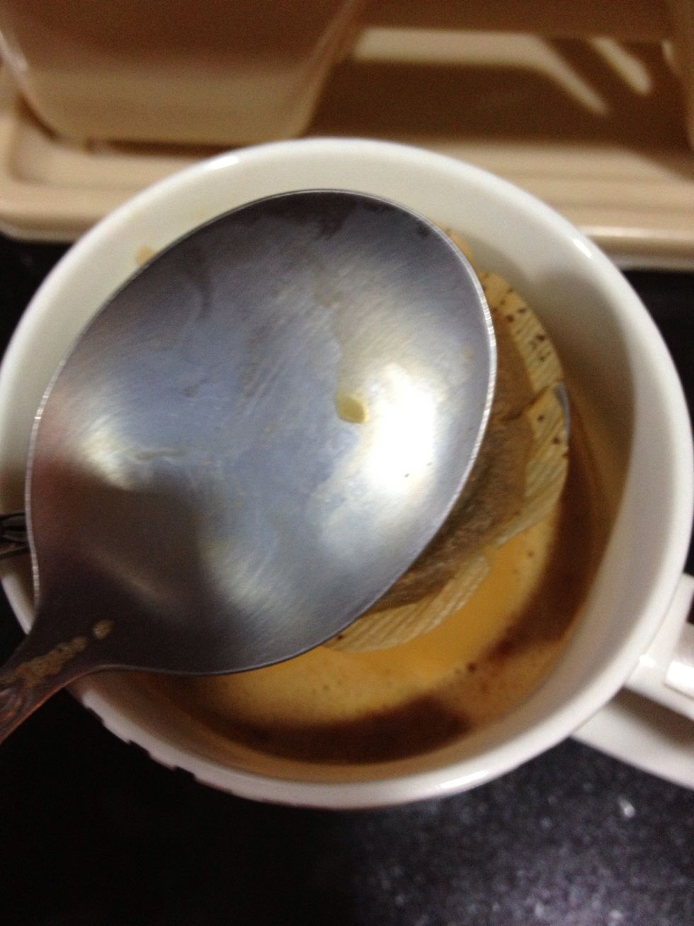 Using two tablespoons, squeeze excess liquid from the tea bag.