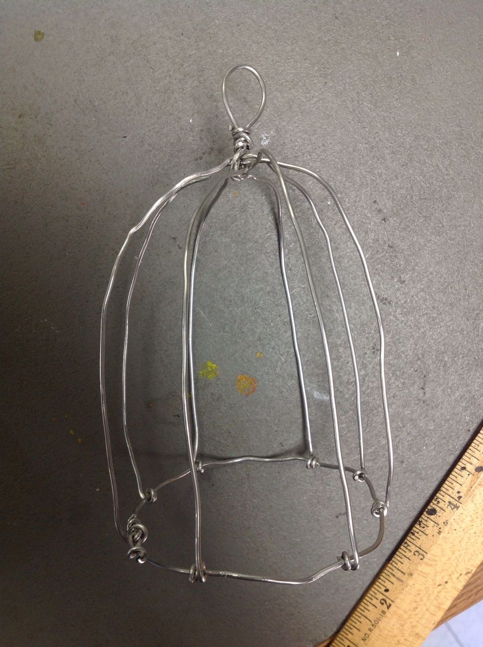 Using you hands, stretch, smooth, straighten, and bend the wires till they resemble a birdcage.