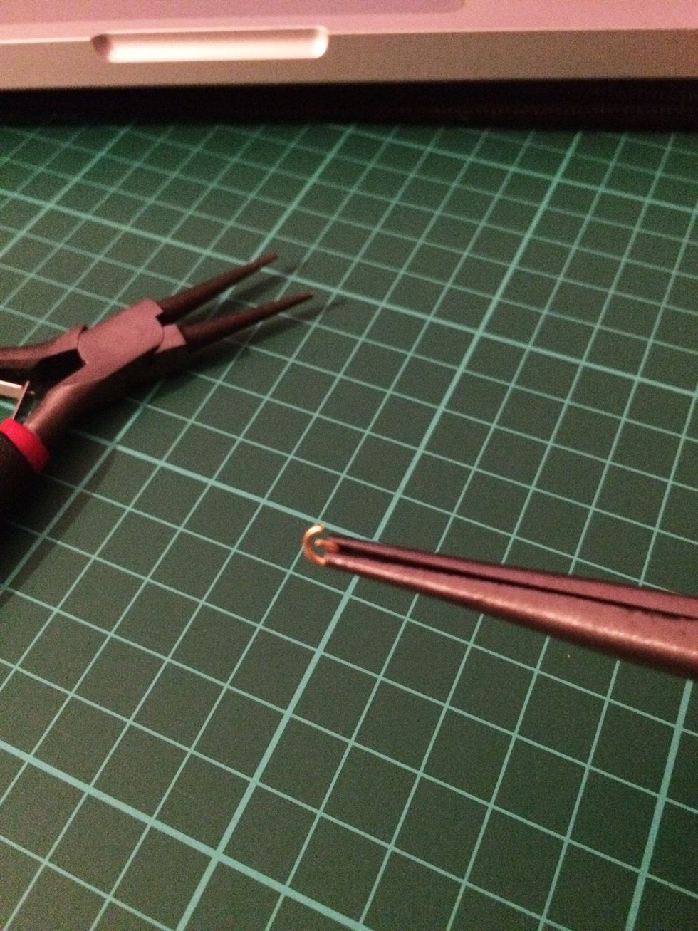 Using your chain nose and round nose pliers, open a jump ring, making sure to pull one of the pliers in your direction and the other in the opposite direction as to not distort the ring's shape.