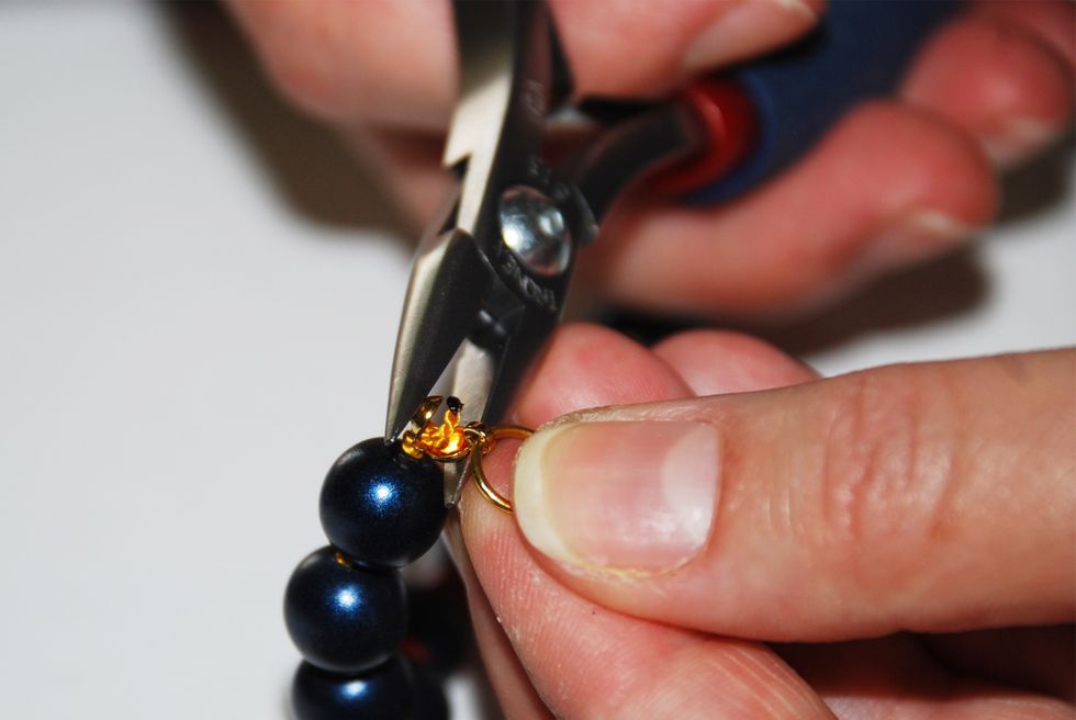 Using your chain nose pliers, carefully grasp the clamshell between the jaws of the pliers and squeeze. Close the clamshell by applying gentle steady pressure.