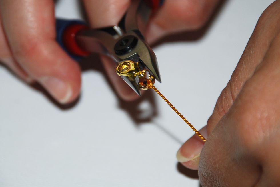 Using your chain nose pliers, carefully grasp the clamshell between the jaws of the pliers and squeeze. Close the clamshell by applying gentle steady pressure.