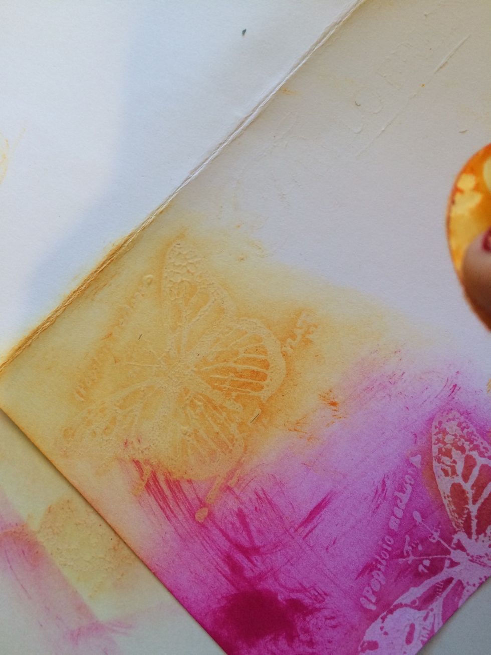 Using your cotton pads and your Tim Holtz Distress Ink, rub your selected colors in swirls all over your card, including over your images.