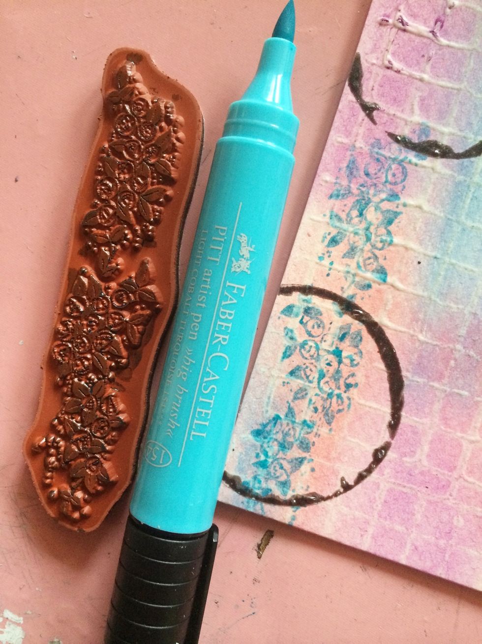 Using your Faber Castell Pitt artist pen, color the flower stamp and stamp the bottom left corner. Then randomly stamp other places on your board (re-inking as necessary.)