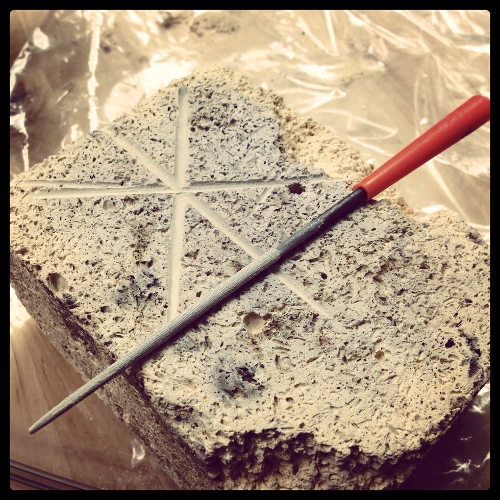 Using your file point, score three crossing grooves in your soft fire brick.