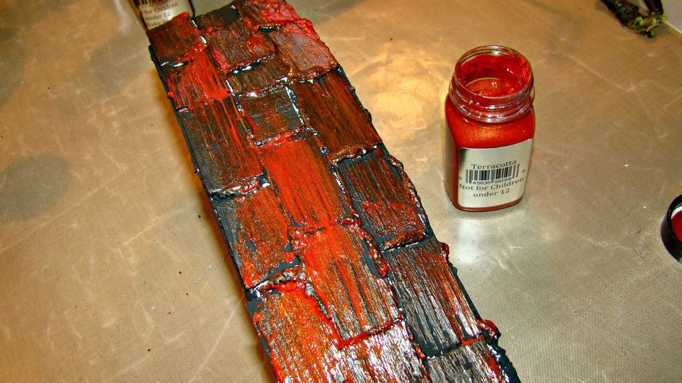 Using your finger swipe the rust colored paint over the top of the piece and allow to dry somewhat and then rub off with baby wipe to allow color to penetrate in the cracks of your coffin.