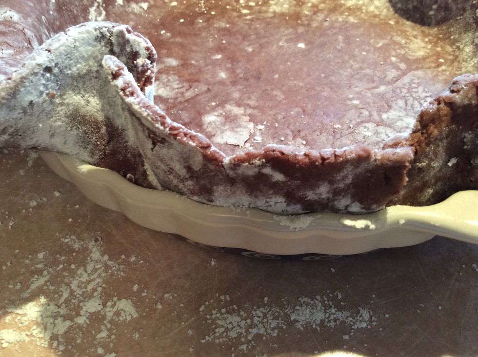 Using your fingers tuck the dough down into the pie plate, making sure the dough is in full contact with the side of the pie plate.