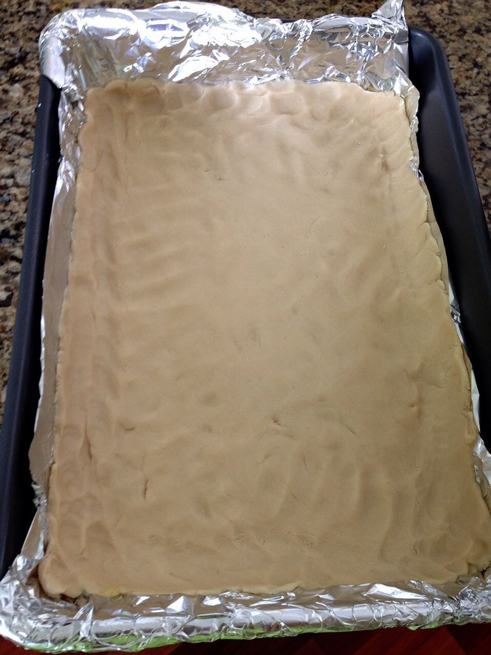 Using your hand to press the dough down firmly. Try to add some dough up the sides of pan to help keep the lemon mixture from spilling out later. Place in oven for 20 minutes.