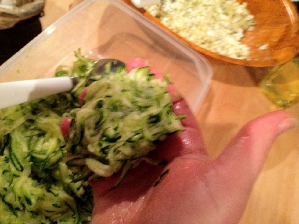 Using your hands as you're making snowballs, squeeze the juice out of the courgettes.