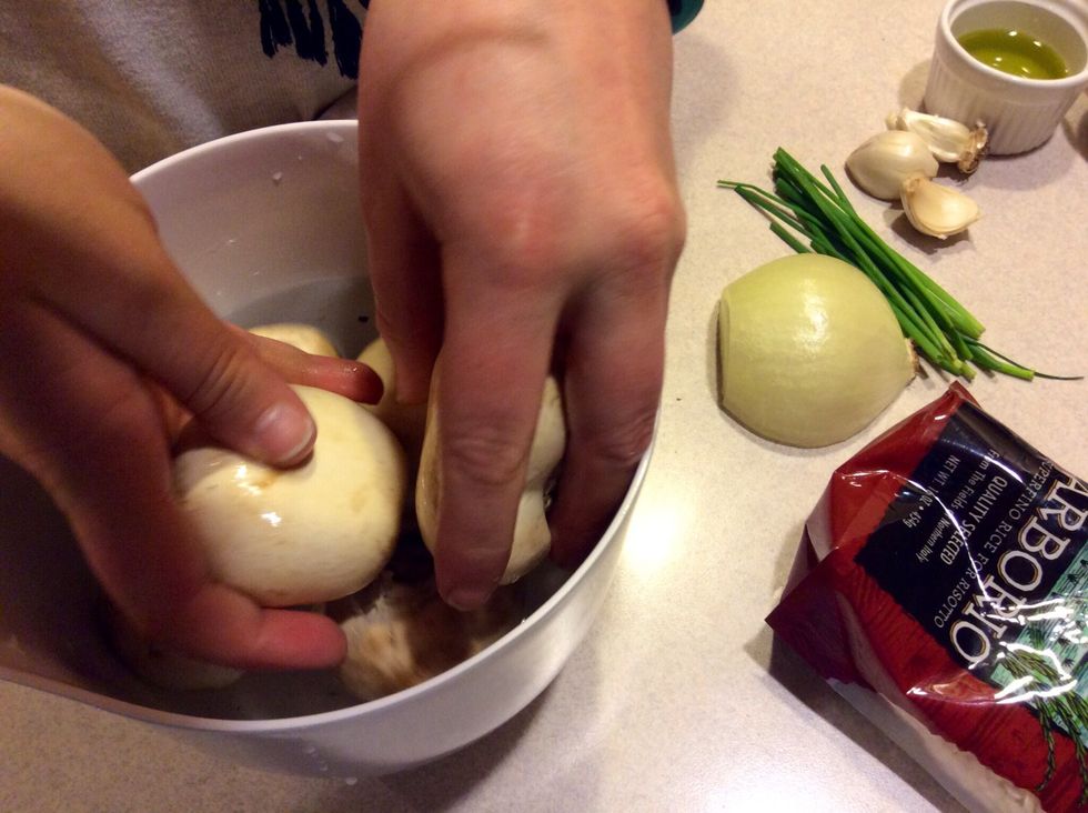 Using your hands rub the mushrooms to remove all of the dirt. Do not let the mushrooms just sit in the water, drop them in, rub to remove dirt and immediately remove from the water.