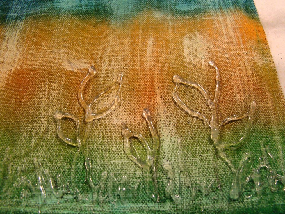 Using your hot glue, draw stems with leaves, grass etc. The glue gun is a great way to add dimension to any project, then you can just paint or gesso over the top.