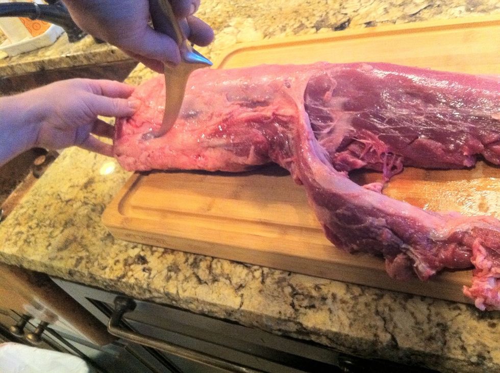 Using your knife, carefully cut through the membrane at the wide end of the loin so that you can finish separating the two muscles. Save the smaller muscle for use in stew, chili, or other recipes.