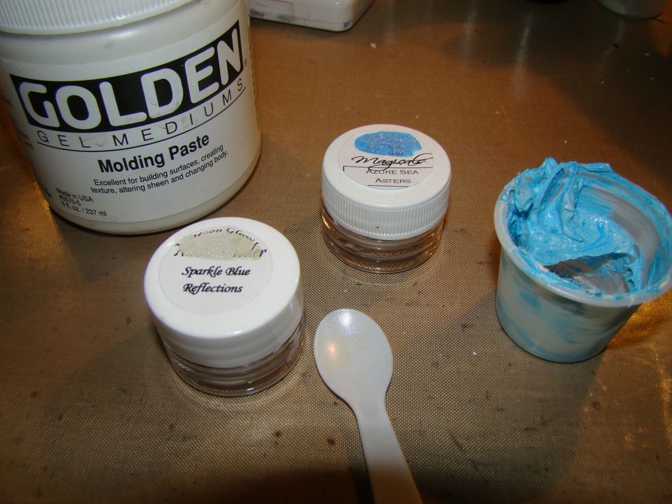 Using your molding paste, make free form clouds in the sky leaving peaks for texture. Mix a small amount of molding paste with Magical Micas and top the clouds with a bit of this mixture.