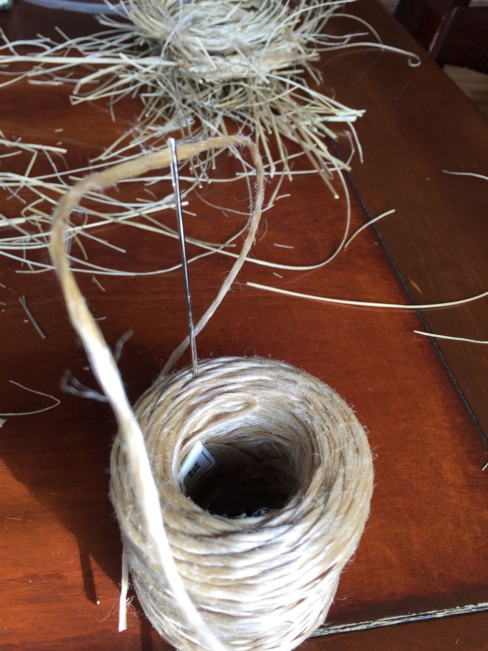 Using your needle threaded with a long piece of twine, sew through, around and about the rings and bottom.