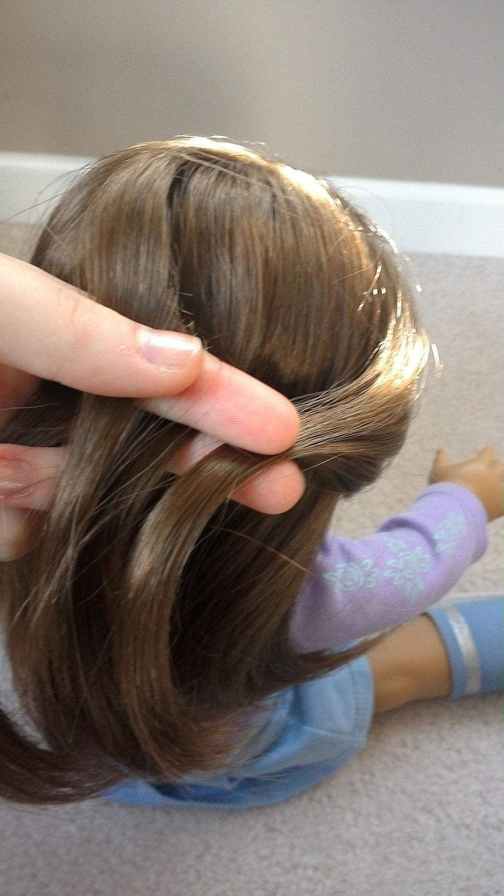 Using your other hand (mine not pictured) grab a small section of hair from the right side of the head and pull it back.