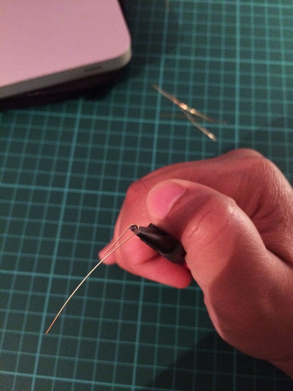 Using your round nose pliers, wrap the wire around the tip at about 1cm down the wire. Wrap the piece around the bottom of the loop.