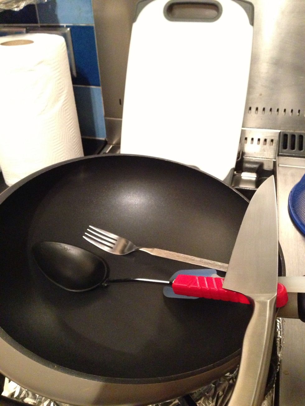 Usual utensils needed for cooking in a wok, and a knife and board for the veg.