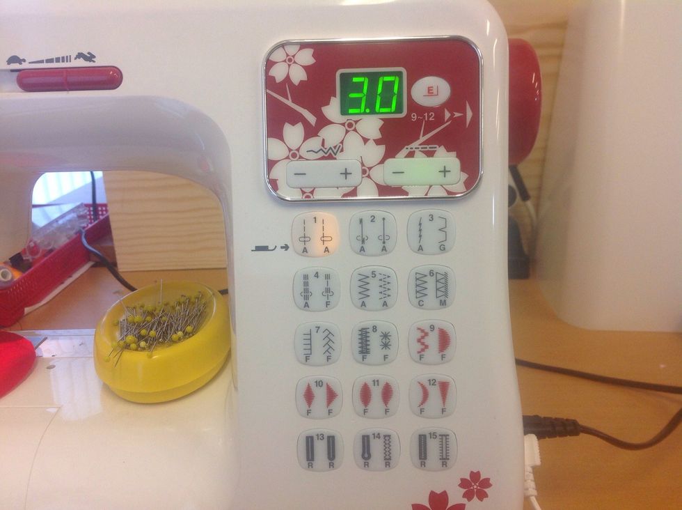 V\u00e4lj den v\u00e4nsterst\u00e4llda raks\u00f6mmen genom att trycka p\u00e5 knapp 1 s\u00e5 att knappen lyser gult ist\u00e4llet f\u00f6r gr\u00f6nt. \u00d6ka stygnl\u00e4ngden till 3 genom att trycka p\u00e5 plus p\u00e5 den h\u00f6gra knappen l\u00e4ngst upp.