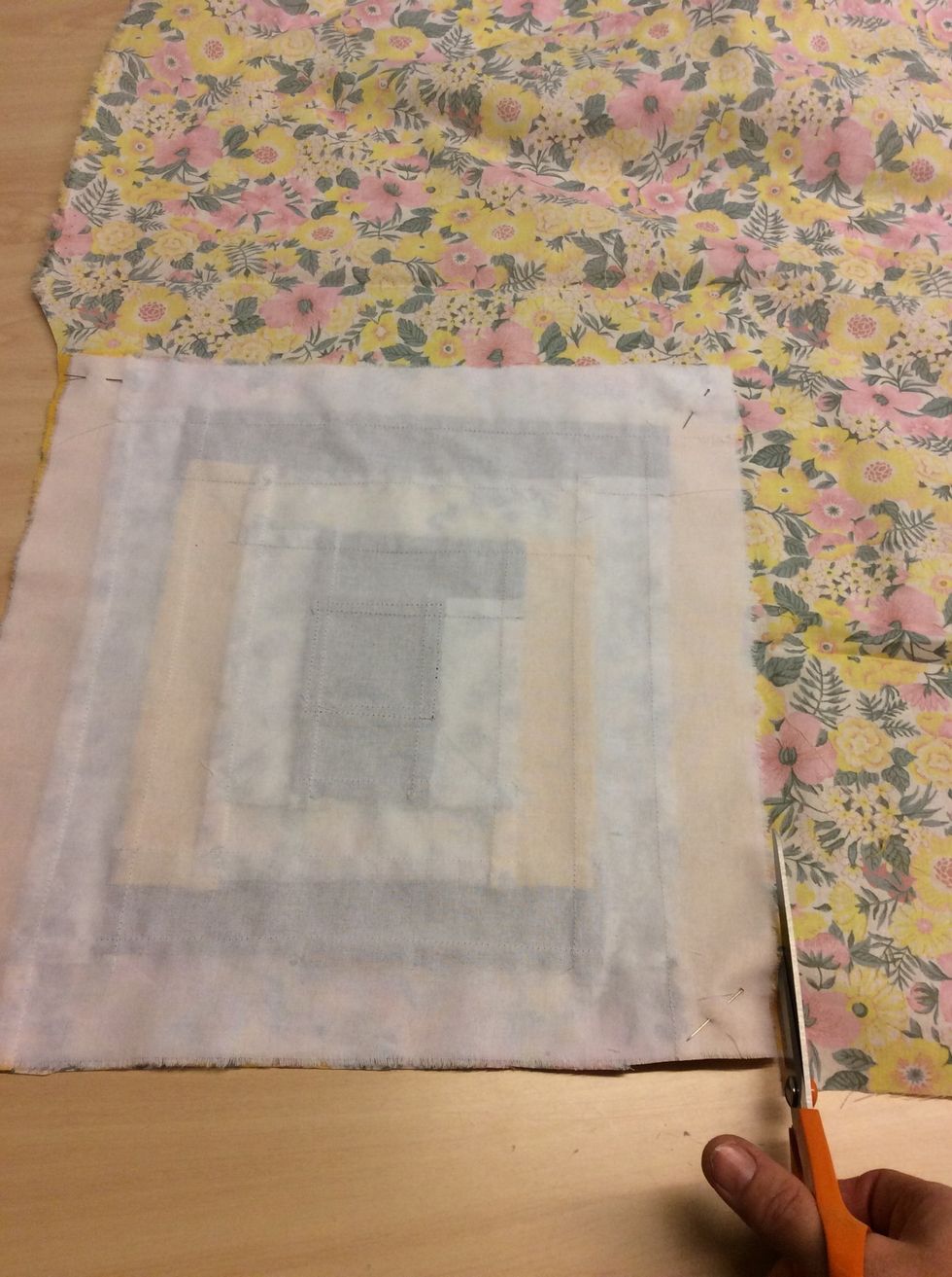 V\u00e4lj nu ut ett tyg till baksidan. L\u00e4gg din lappteknik p\u00e5 tyget du valt med r\u00e4tsidan ner\u00e5t och n\u00e5la fast tygerna med varandra, en n\u00e5l i varje h\u00f6rn. Klipp sedan ut.