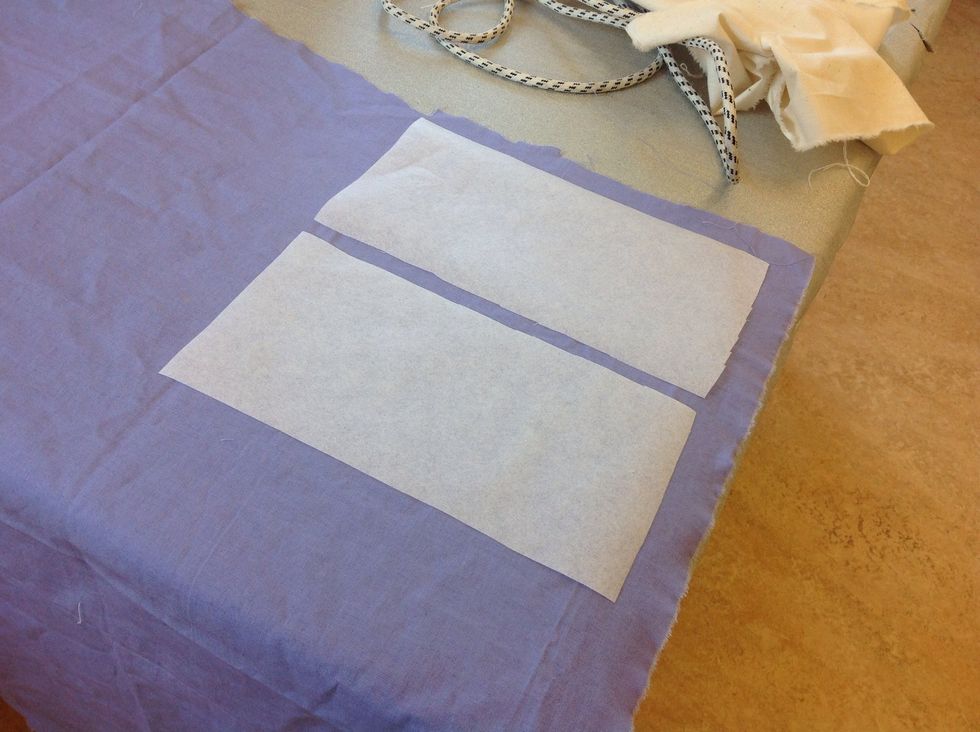 V\u00e4lj tyg. Du kan v\u00e4lja samma tyg till b\u00e5da bitarna, eller olika. Det g\u00e5r bra att v\u00e4lja m\u00f6nstrat eller enf\u00e4rgat tyg. L\u00e4gg dina vliselinebitar med den blanka sidan mot tygets avigsida (baksidan)