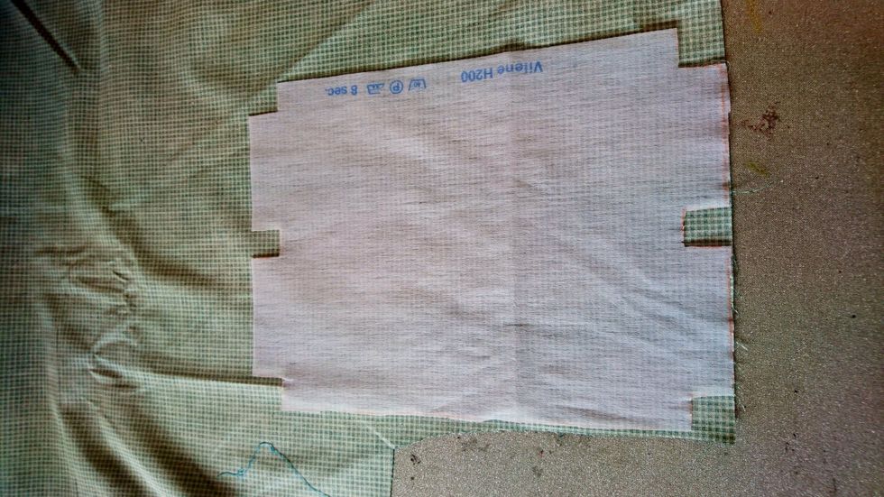 V\u00e4lj tyg.L\u00e4gg vlieselinet p\u00e5 tygets avigsida med den blanka sidan ner.