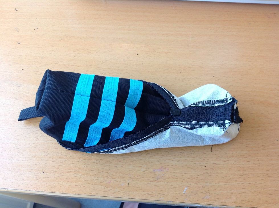 V\u00e4nd f\u00f6rsiktigt pennskrinet ut och in genom den \u00f6ppna delen i dragkedjan.