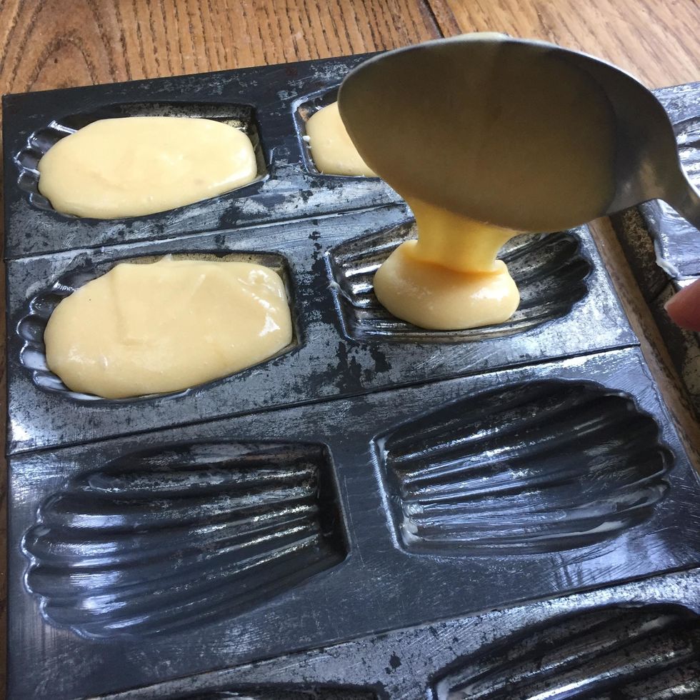 Verser la p\u00e2te dans les moules \u00e0 l'aide d'une cuill\u00e8re \u00e0 soupe (ici ils sont un peu trop remplis : normalement ils doivent seulement \u00eatre remplis aux 3/4).