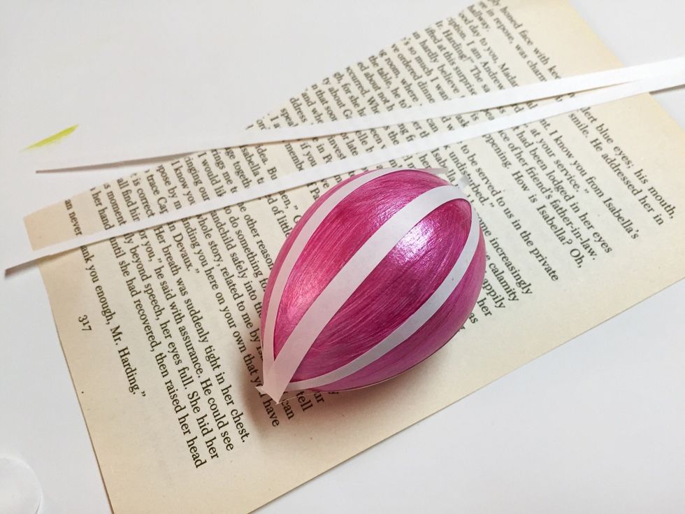 VERTICAL STRIPED EGG: cut narrow strips from adhesive sheet the length of the egg plus a bit. apply strips to egg as shown, spacing evenly. rub strips with finger to transfer adhesive.