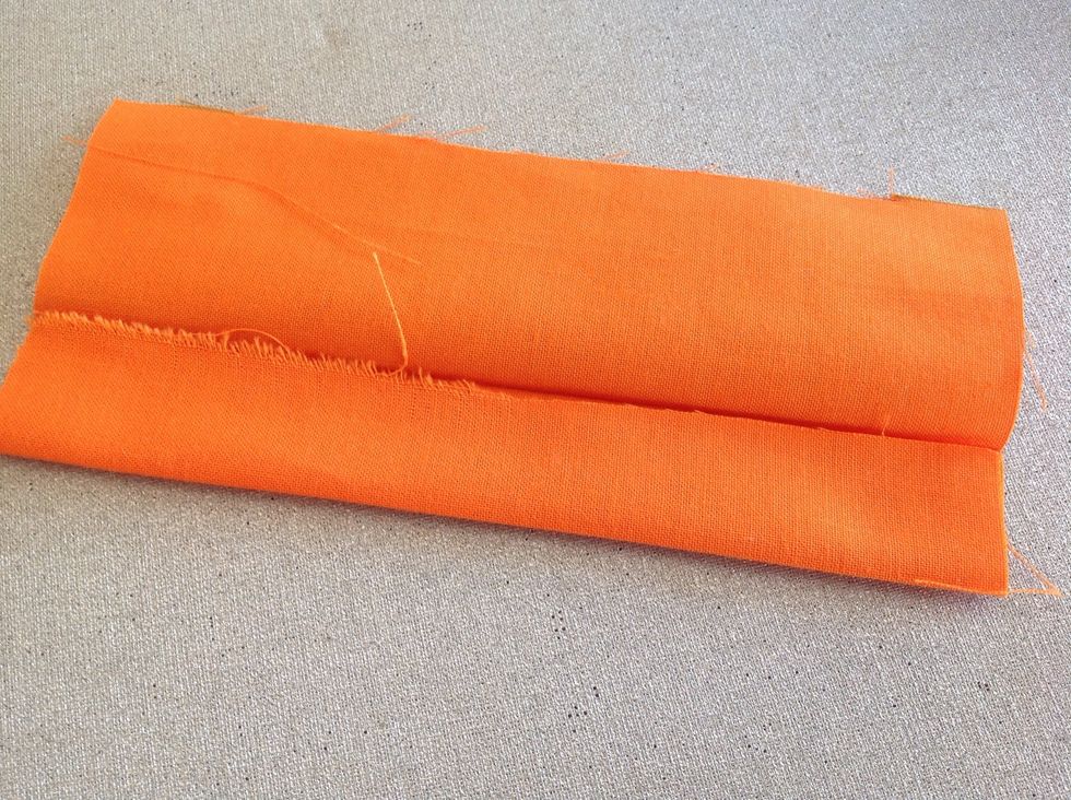 Vik den dubbel p\u00e5 l\u00e4ngden och stryk. \u00d6ppna och vik in b\u00e5da kanterna mot mitten och stryk igen.