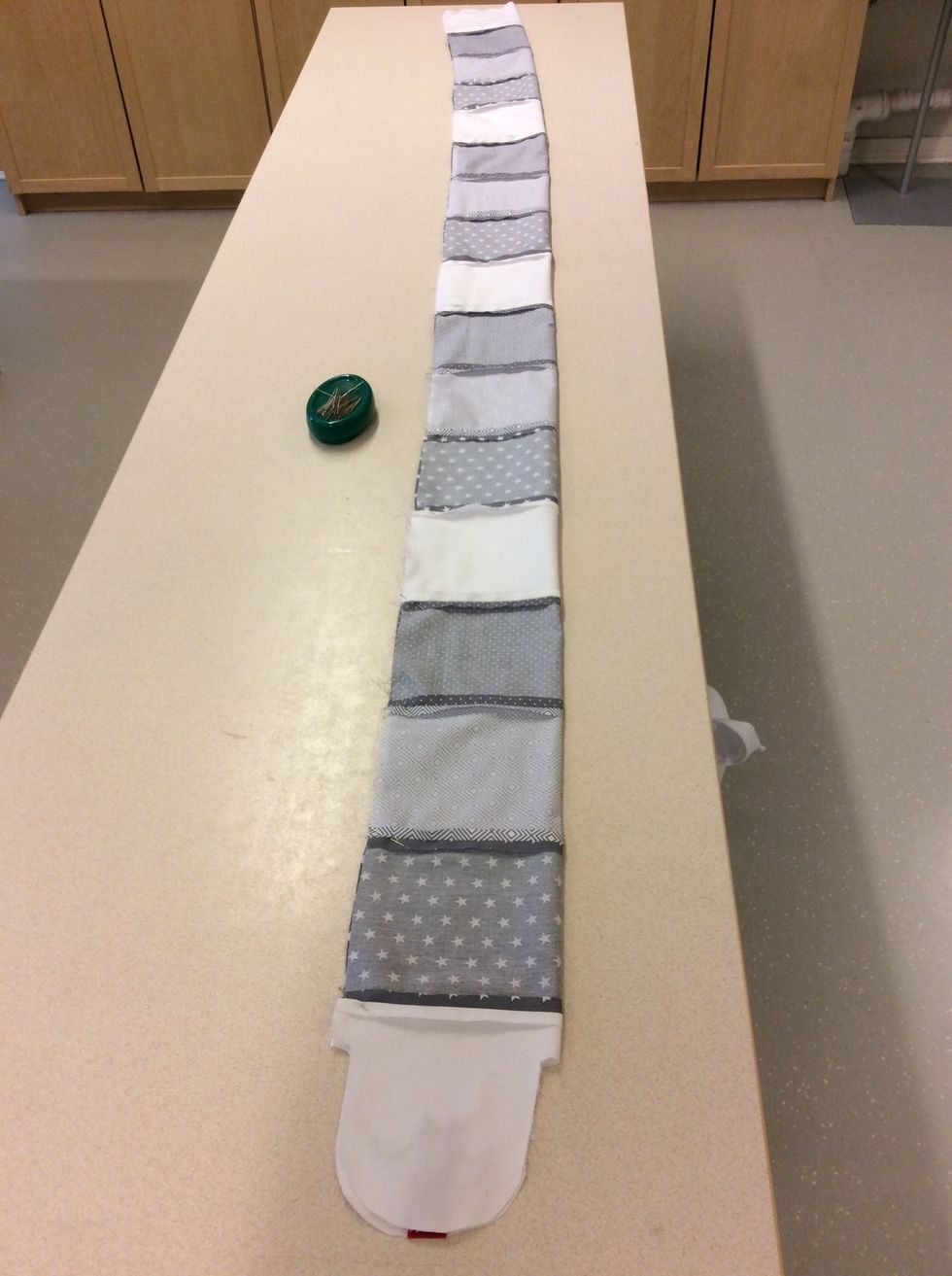 Vik ihop ormen p\u00e5 mitten med r\u00e4tsidan in\u00e5t. S\u00e4tt en n\u00e5l vid varje s\u00f6m. Se \u00e4ven n\u00e4sta bild.