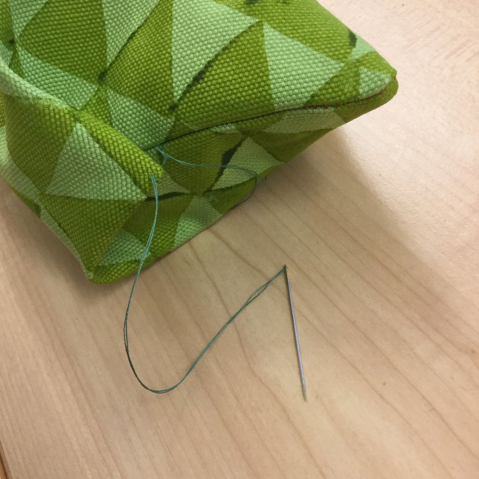 Vik in ena h\u00f6rnet och sy fast det med tr\u00e5den.