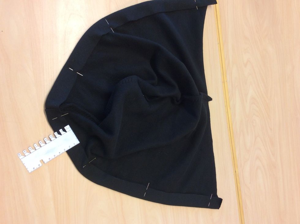 Vik och n\u00e5la in 3 cm av luvans framkant mot avigsidan (baksidan)