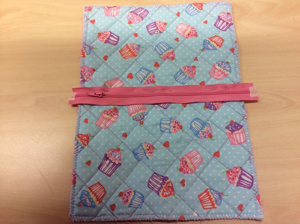 Vik tyget p\u00e5 mitten och n\u00e5la fast dragkedjan d\u00e4r.