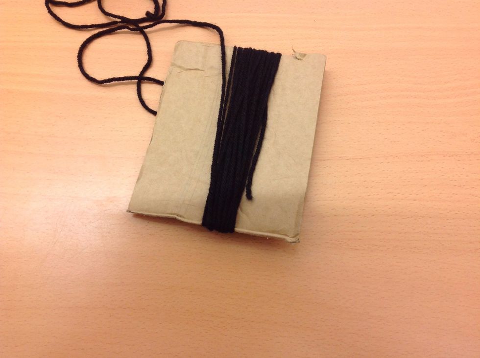 Vira svart garn 25 varv runt kartongbiten. (20cm)