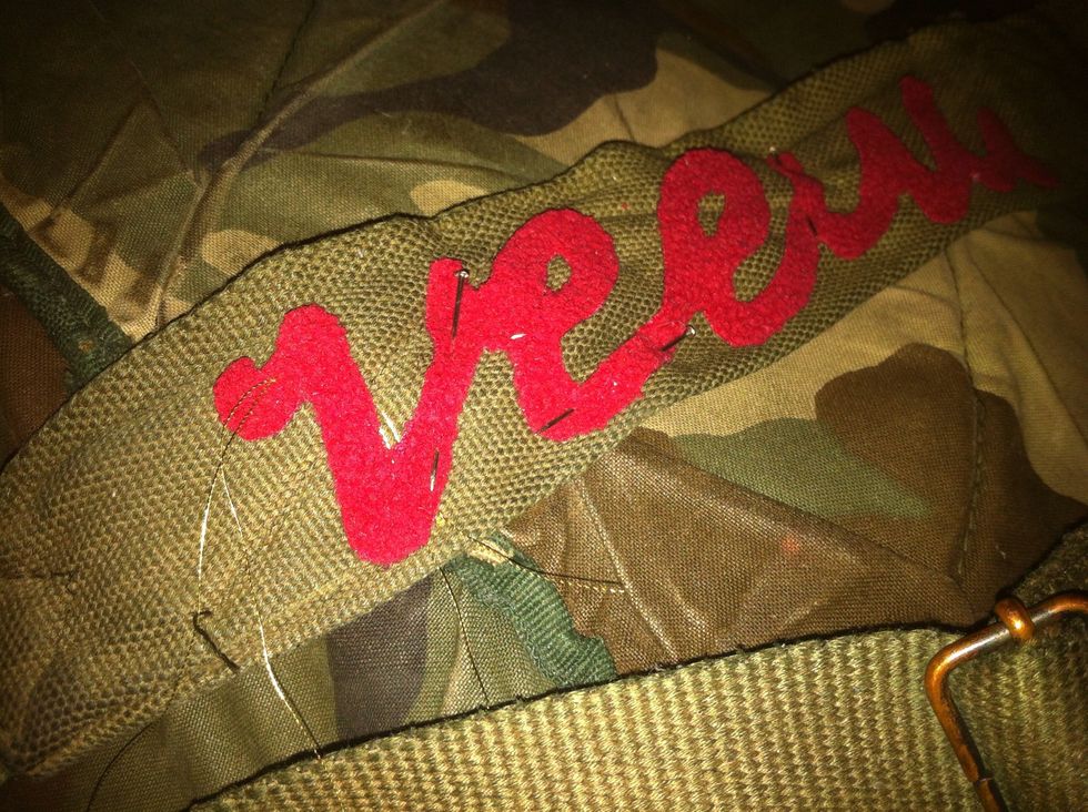 W/your threaded needle dangling, position your appliqu\u00e9 on the garment of your choice and secure it into place with straight pins. Don't worry if it isn't perfect; you can adjust it as you go along.