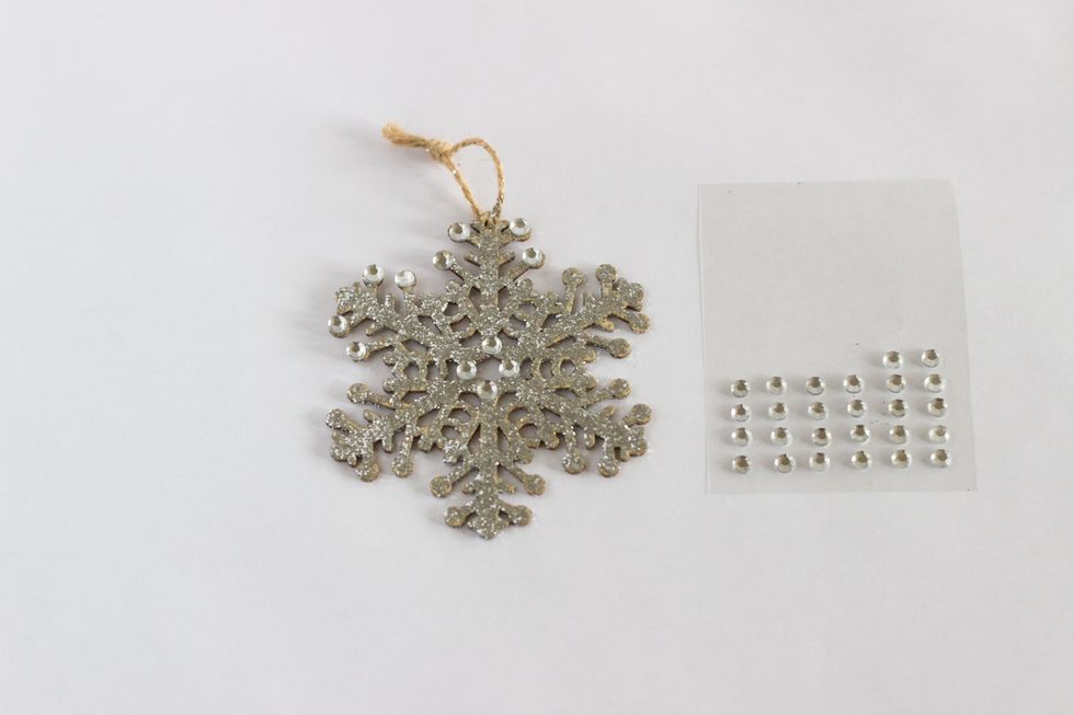 Wait till the snowflake is completely dry. Once dry, apply adhesive rhinestone stickers to the ball points of the snowflake and in the middle. You can be as creative as you want.