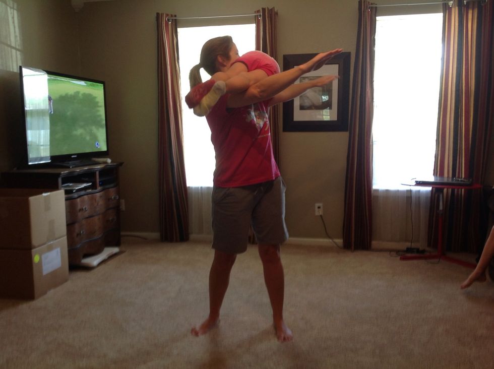 Want to take it up a notch? Roll the child up to your shoulders and see how many of the torso twists and squats you can get in before you need to kiss the child's tummy!