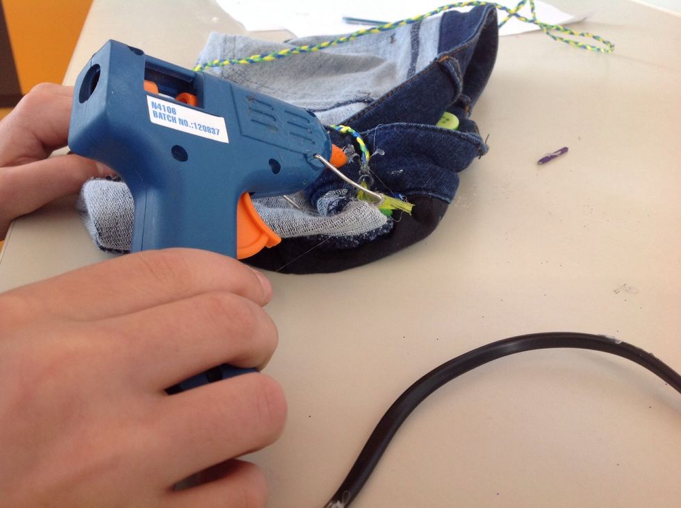 Warm up your hot glue gun and then hot glue the end of your plated string to the upper inside end and then do the same thing to the other side !