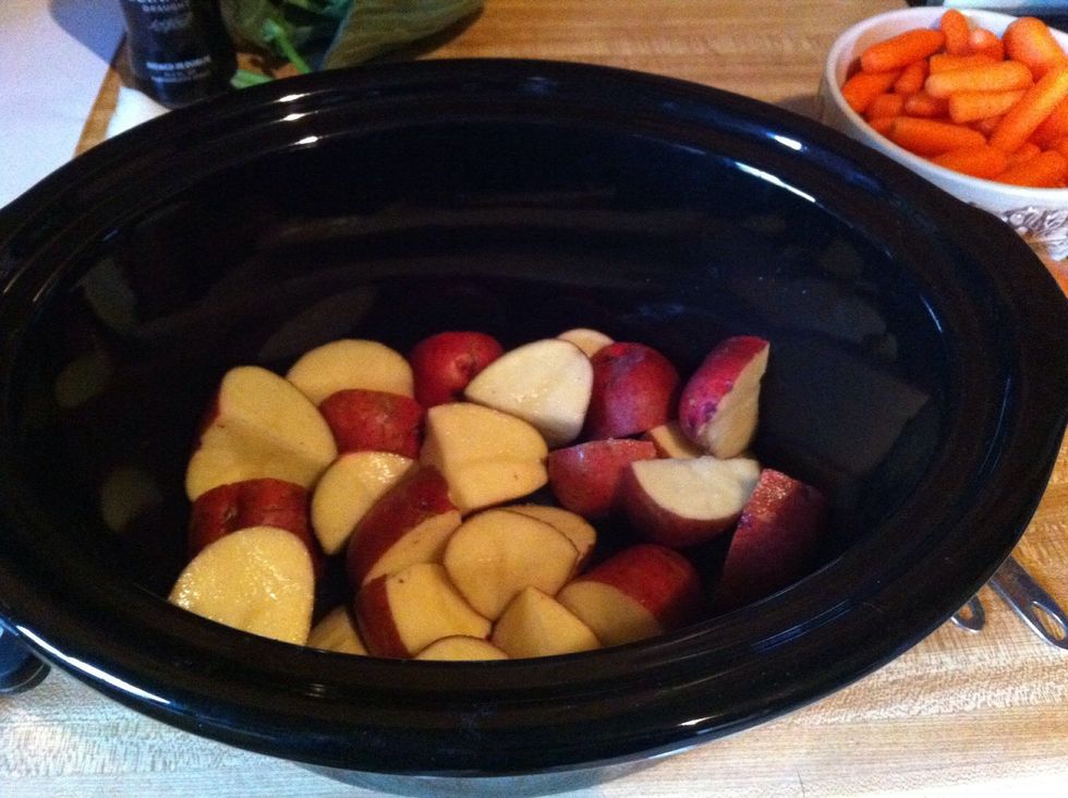 Wash 5-6 small red potatoes really well, quarter and put in crock pot