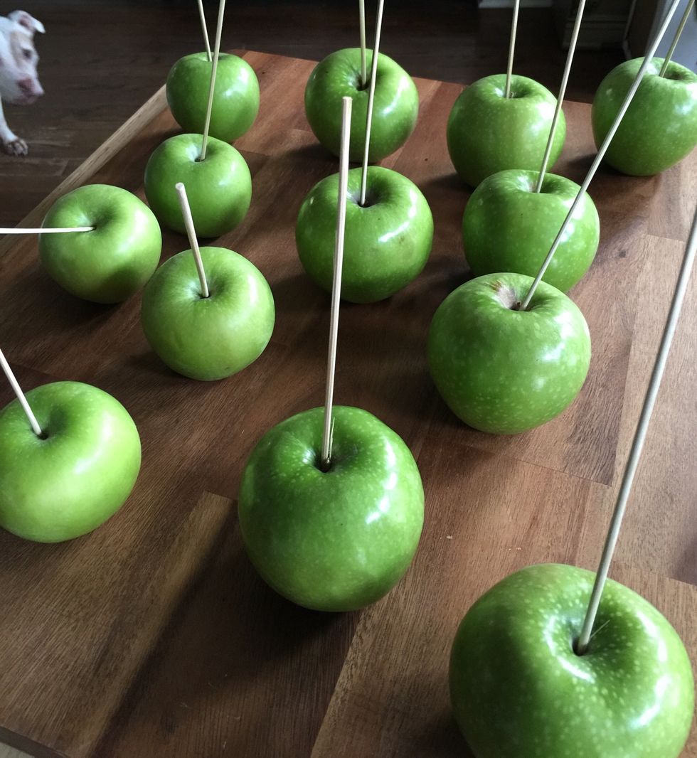 Wash apples and pat dry. Stick skewers or Popsicle sticks in the top of apple.