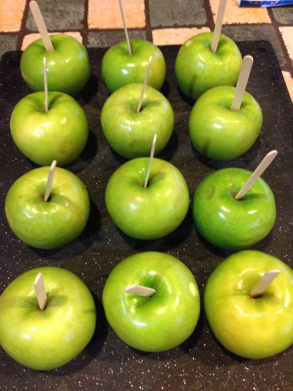 Wash,dry & remove apple stems. Insert Popsicle stick directly into the core
