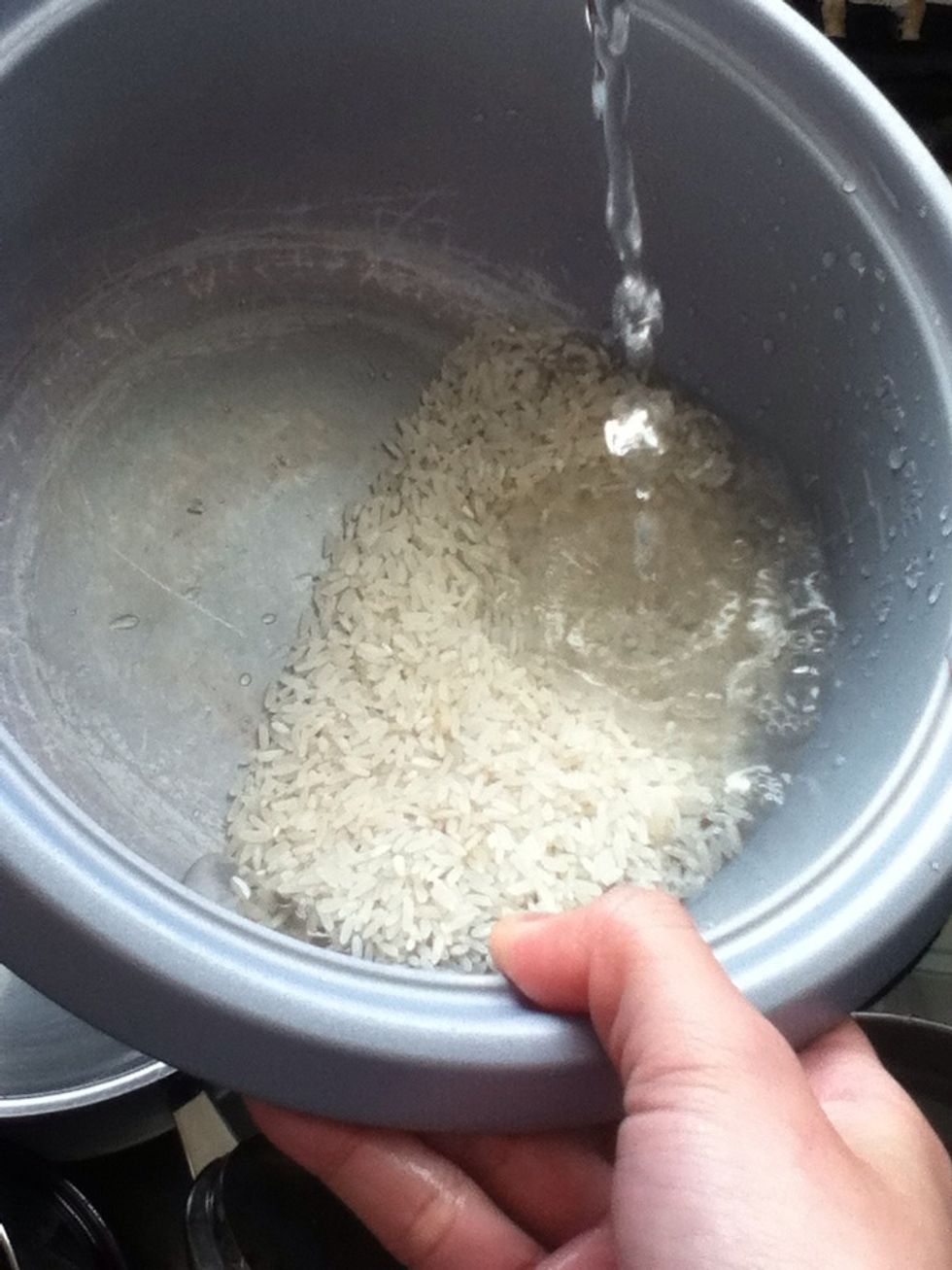 Wash rice with water.