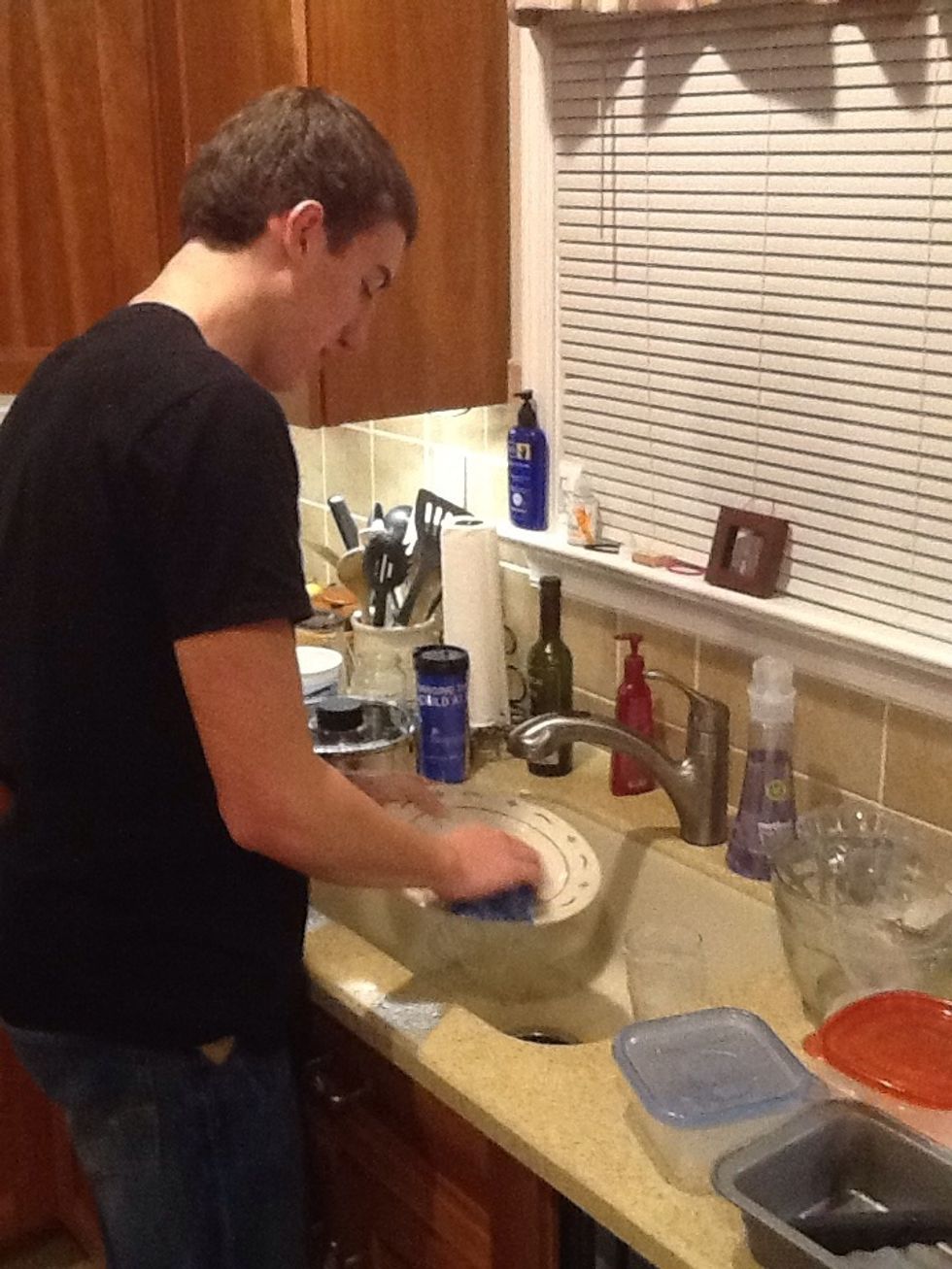 Wash the dishes with the soaped up sponge