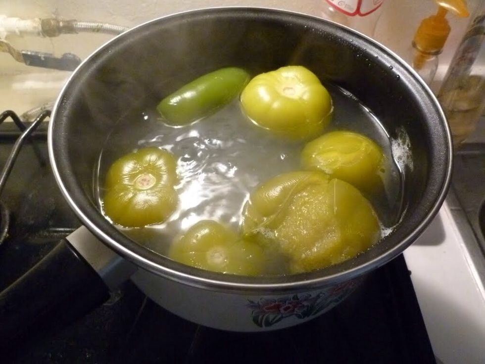 (Wash the ingredients) Boil the green tomatoes and chiles in a pot in temperature medium like 5 min... (All)