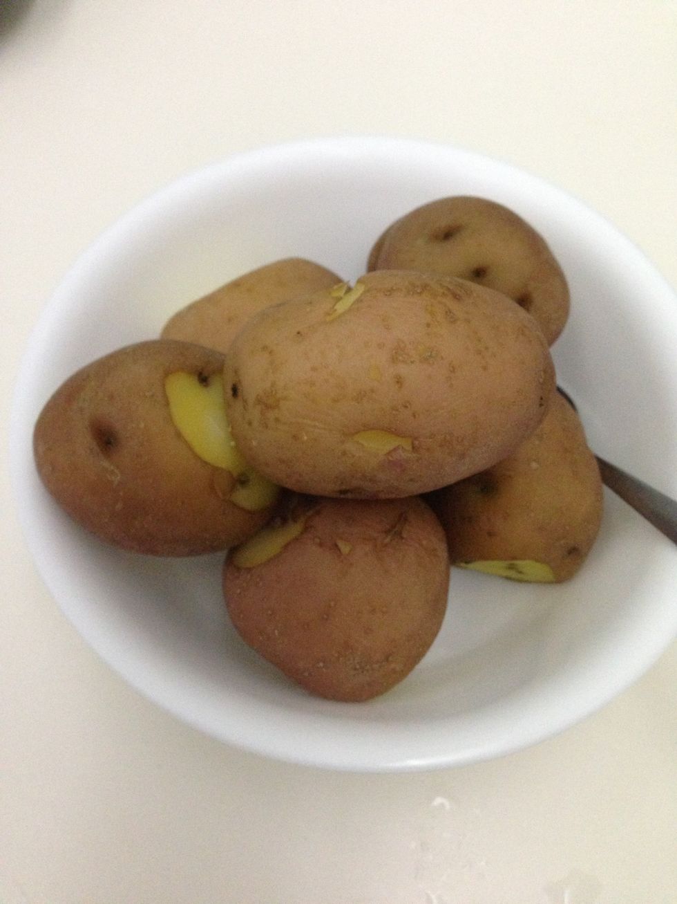 Wash the potatoes and cook them in boiling water until partially cooked