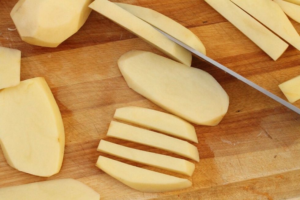 Wash the potatoes. Then (if you don't want the skin), take if off with a peeler. Next, cut the potatoes in 4th's length wise and then cut into that perfect French fry shape.