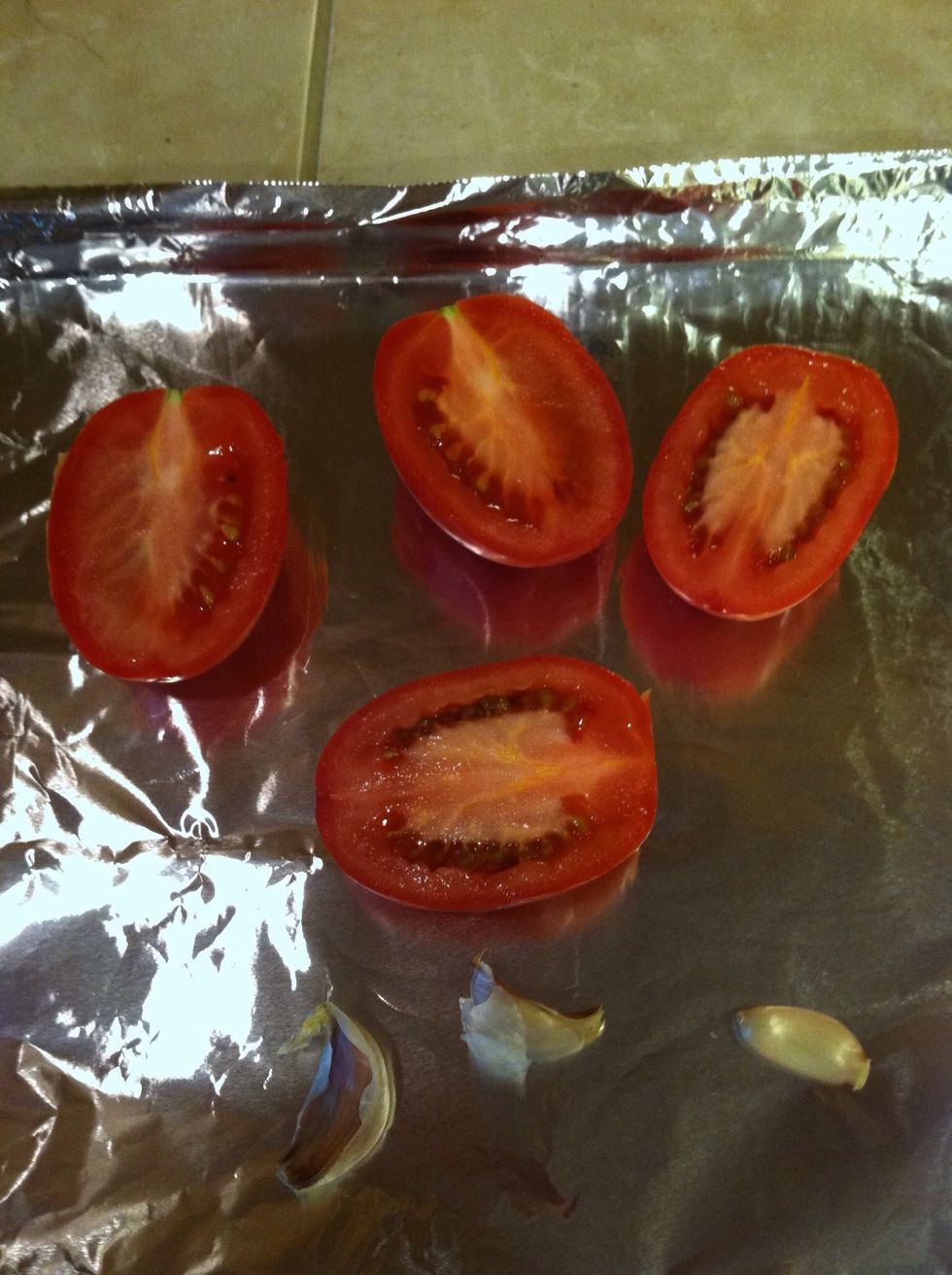 Wash tomatoes and cut in half, add them with the garlic. Put back in broiler. U can also use a nonstick pan if u like.