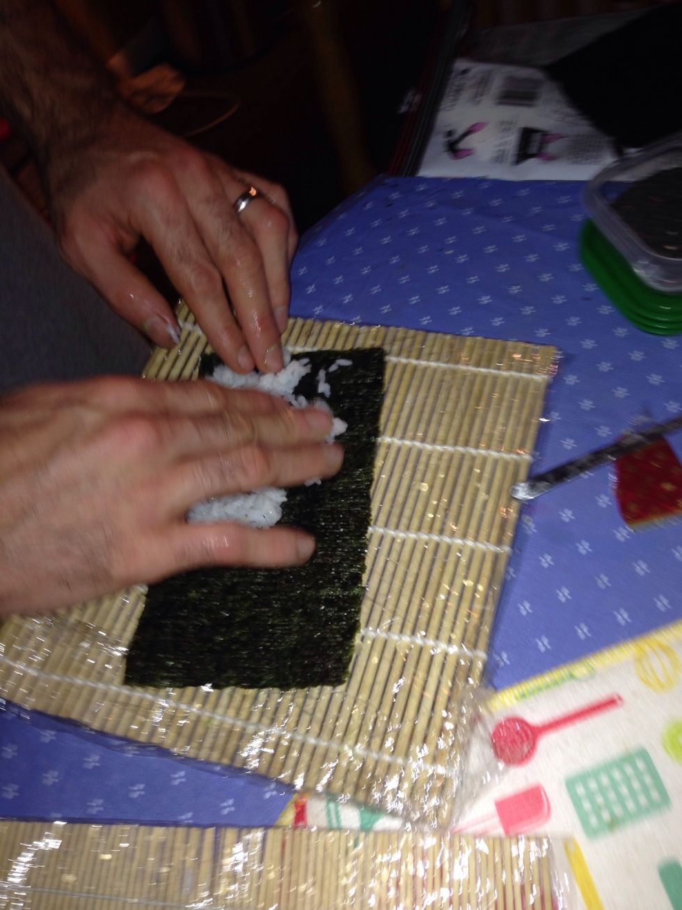 Wash your hands a little bit and grab a little bit of rice not too much just enough to cover the seaweed leave some space empty on the top of seaweed. It can let u seal the roll easier.