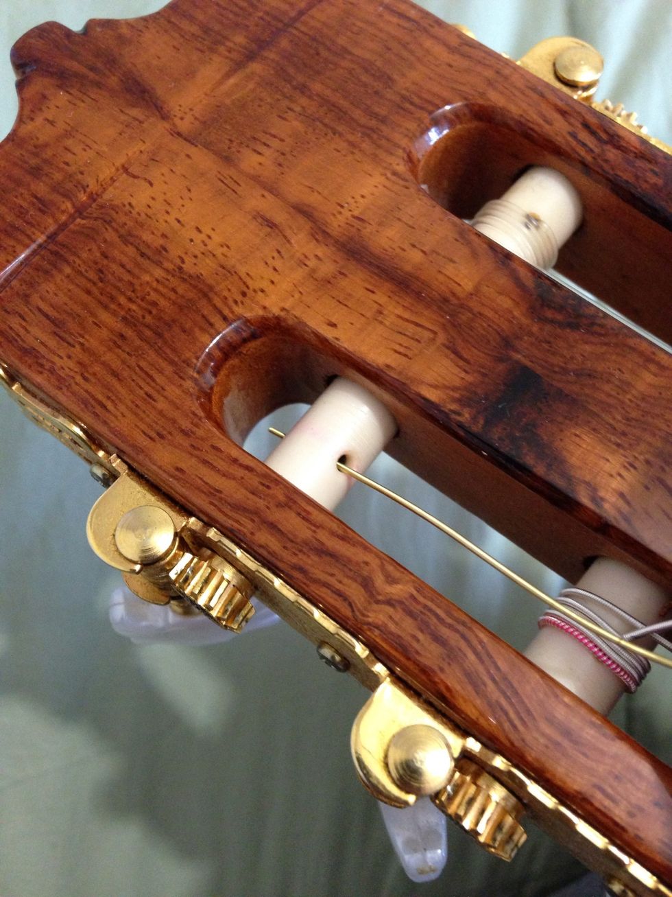 We are halfway! Now, insert the remaining end of the string in the top bridge.
