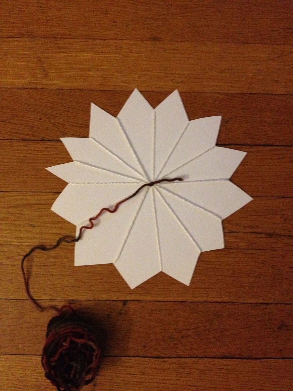 We are now ready to start weaving. Tie one end of the brown yarn to the center of your sunflower.